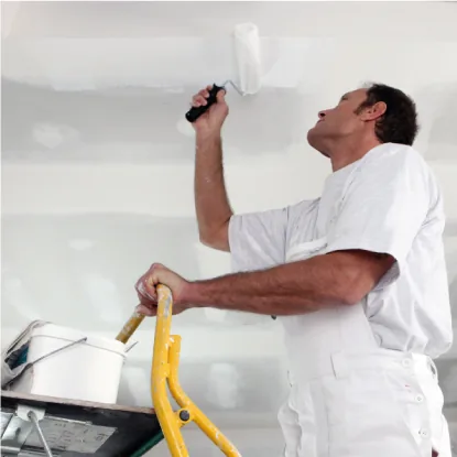 Operario de mantenimiento de Asistum pintando un techo